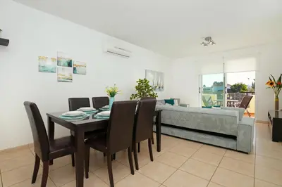 a dining room with a table and chairs and a couch at Neraida - 2Bed Apart walk to Kalamies Beach in Protaras