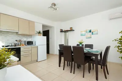 a kitchen and dining room with a table and chairs at Neraida - 2Bed Apart walk to Kalamies Beach in Protaras