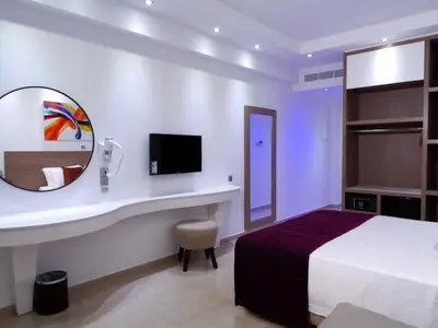 a hotel room with a bed and a mirror at Amethyst Napa Hotel & Spa in Ayia Napa