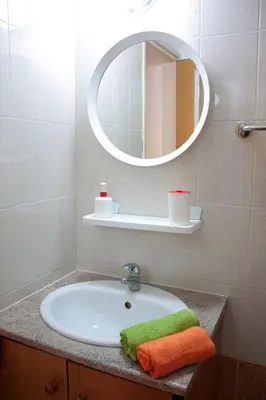 a bathroom with a sink and a mirror at Makenzy Apartment in Larnaka