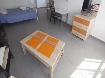 a room with a table and a bed and a desk at Studio Apartment Near the Beach in Larnaka