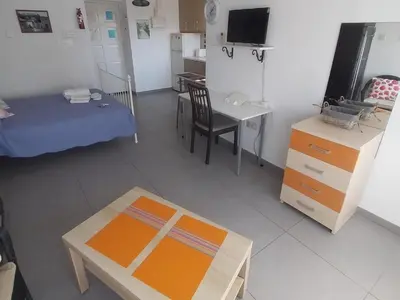 a room with a bed and a table and a desk at Studio Apartment Near the Beach in Larnaka