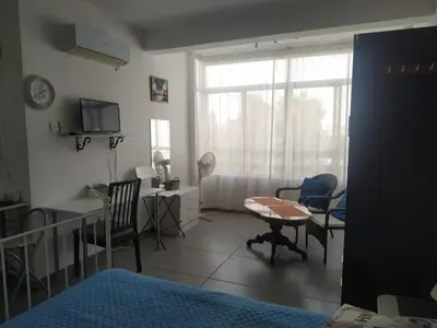a bedroom with a bed and a desk and a window at Studio Apartment Near the Beach in Larnaka