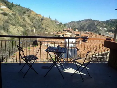 two chairs and a table on a balcony with a mountain at Maritsa Lodge in Kakopetria