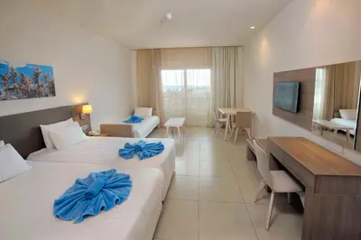 a hotel room with two beds and a desk at Euronapa Hotel Apartments in Ayia Napa