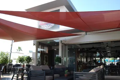 a restaurant with tables and chairs under a red umbrella at Euronapa Hotel Apartments in Ayia Napa