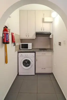 a kitchen with a washing machine and a microwave at Mackenzie Blu Beach Studio in Larnaka