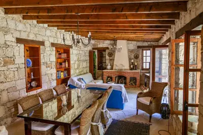 a living room with a stone wall and a table and chairs at Listed Villa in Laneia in Lania