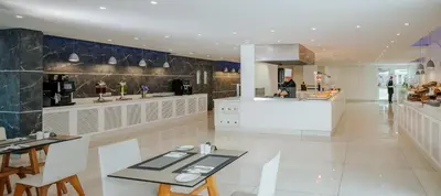 a restaurant with a counter and a table and chairs at Seasons Hotel (Adults Only) in Ayia Napa