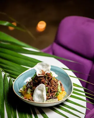 a plate of food on a table with a purple chair at Seasons Hotel (Adults Only) in Ayia Napa