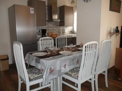 a kitchen with a table with chairs and a table cloth at SUNSHINE APTS, TWO BEDROOM , FREE INTERNET, No 3 in Ayia Napa