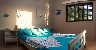 a bedroom with a bed with blue sheets and pillows at Annita Court Block B, Apt6 in Ayia Napa