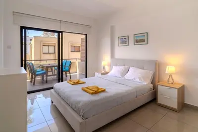 a bedroom with a bed and a balcony with a table at Lazaros Suite Downtown in Larnaka