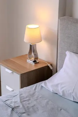 a lamp on a night stand next to a bed at Lazaros Suite Downtown in Larnaka