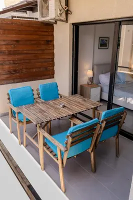 a wooden table and chairs on a balcony at Lazaros Suite Downtown in Larnaka
