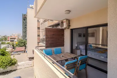 a balcony with a table and chairs and a bedroom at Lazaros Suite Downtown in Larnaka