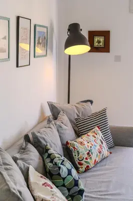 a room with a couch with pillows and a lamp at Lazaros Suite Downtown in Larnaka