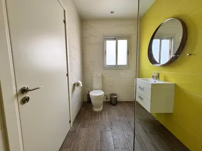 a bathroom with a toilet and a sink and a mirror at Vega Apartments in Limassol