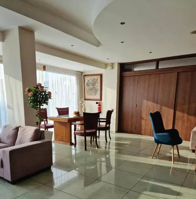 a living room with a couch and a table and chairs at M. Moniatis Hotel in Limassol