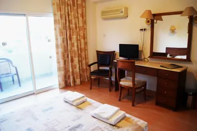 a room with a desk with a computer and a mirror at M. Moniatis Hotel in Limassol