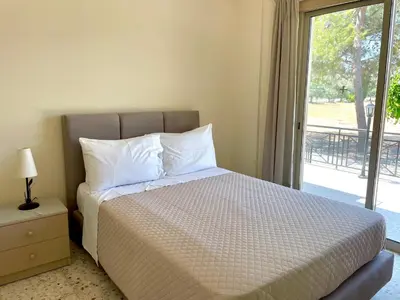 a bedroom with a bed and a window with a view at Himonas Apartments in Pissouri
