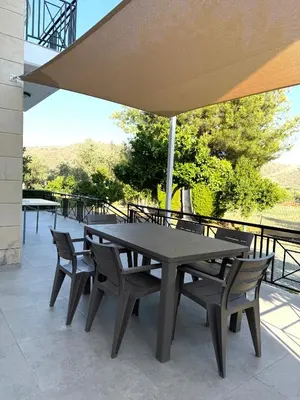 a table and chairs under an umbrella on a patio at Himonas Apartments in Pissouri