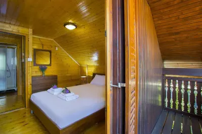 a small bedroom with a bed in a wooden room at Ricky Chalet Near Troodos in Spilia
