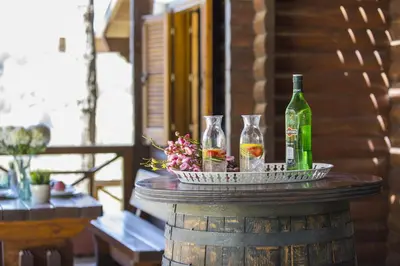 a table with two wine glasses and a bottle at Ricky Chalet Near Troodos in Spilia