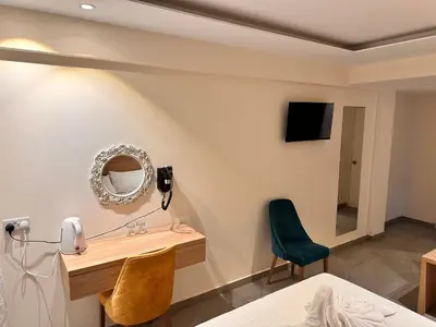 a bedroom with a desk and a mirror on the wall at San Remo Hotel in Larnaka