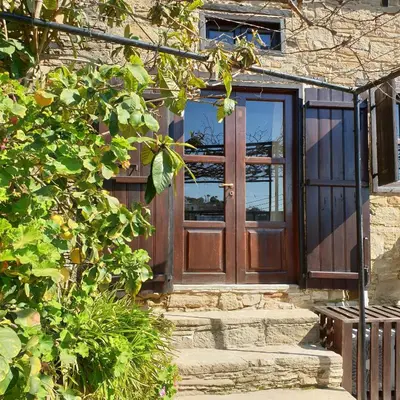 a wooden door of a house with stairs at Vasilopoulos House in Tochni