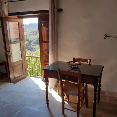a table and chair in a room with a window at Vasilopoulos House in Tochni