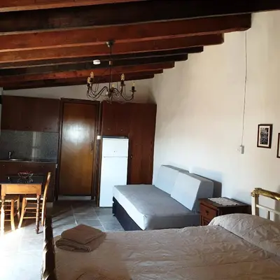 a bedroom with two beds and a table and a kitchen at Vasilopoulos House in Tochni