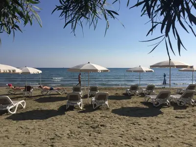 a group of chairs and umbrellas on a beach at 16 SANDY BEACH in Larnaka