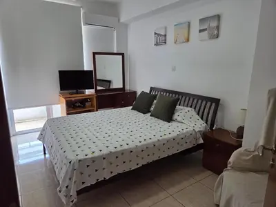 a bedroom with a bed and a mirror and a television at One Bedroom aptm Larnaca in Larnaka