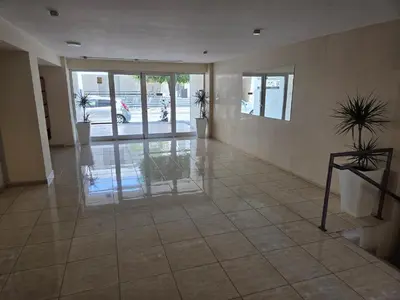 an empty lobby with glass doors and potted plants at One Bedroom aptm Larnaca in Larnaka