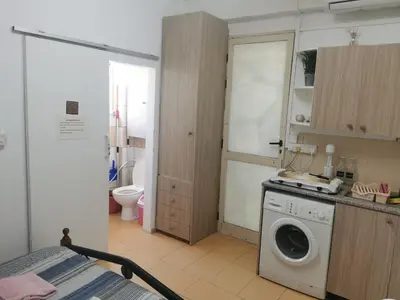 a bathroom with a washing machine in a room at Nicosia rooms Studios in Nicosia