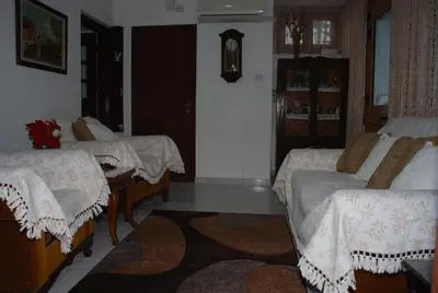 a room with three beds and a clock on the wall at Kanarinis House in Omodos