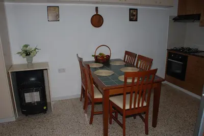 a kitchen with a table and chairs and a stove at Kanarinis House in Omodos