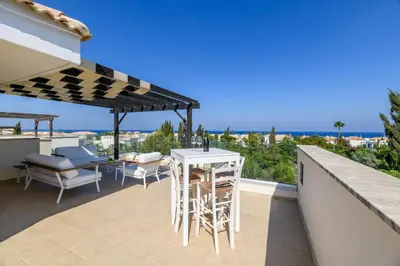 a patio with a table and chairs and an umbrella at Villa Greco Mare #5 in Paralimni