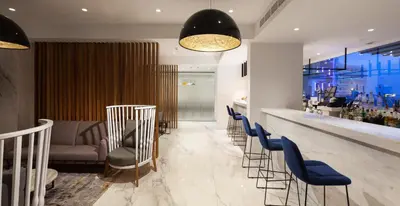 a bar with a row of chairs and a counter at The Blue Ivy Hotel & Suites in Protaras