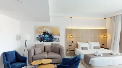 a hotel room with a bed and a couch at The Blue Ivy Hotel & Suites in Protaras
