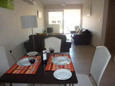 a dining room table with two glasses of wine at Pyla Gardens E107 in Pyla