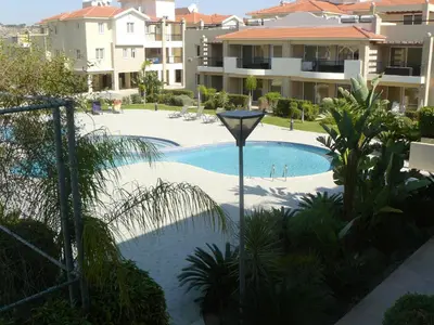 a swimming pool with a light next to some buildings at Pyla Gardens E107 in Pyla