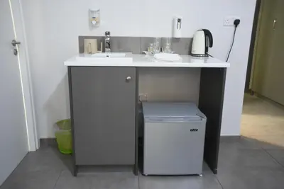 a bathroom with a sink and a trash can under a counter at Rimon Cyprus Israeli Kosher Rooms in Larnaka