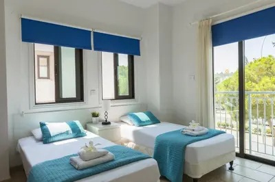 two beds in a room with a window at Protaras Holiday Villa Alexa in Protaras
