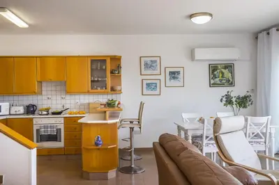 a kitchen and living room with a couch and a table at Protaras Beachfront Sirina Lina Suite in Paralimni