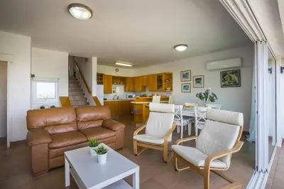 a living room with a couch and a table at Protaras Beachfront Sirina Lina Suite in Paralimni