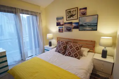 a bedroom with a bed and two lamps and a window at Christos beach house in Larnaka