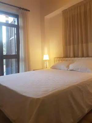 a bedroom with a large white bed with a window at Kalopanayiotis Museum Inn in Kalopanayiotis