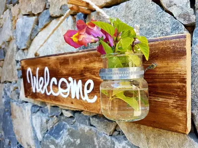a mason jar with flowers in it hanging on a wall at Kalopanayiotis Museum Inn in Kalopanayiotis